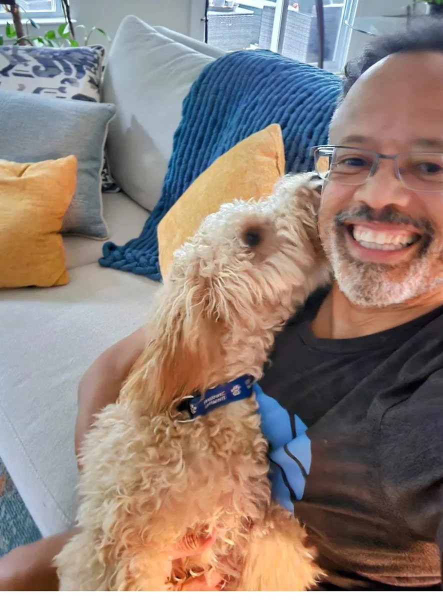 Abraham Abreu at home with his goldendoodle